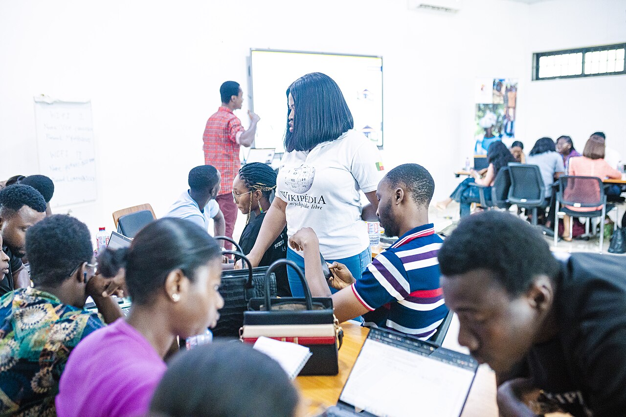 Ghanaian professionals and students collaborating around laptops at a workshop